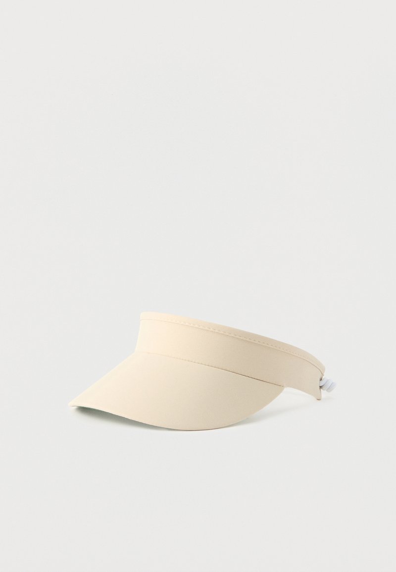 Περούκα ηλίου από μπεζ ύφασμα με ρυθμιζόμενο πίσω λουράκι, σχεδιασμένη για υπαίθρια χρήση και προστασία από τον ήλιο.