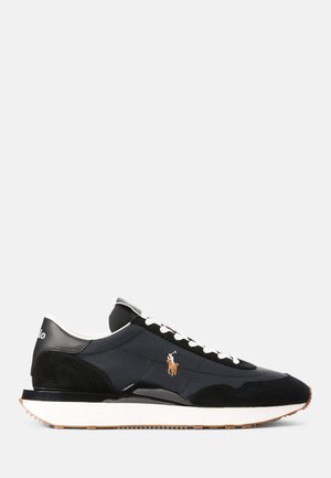 Svart og marineblå sneaker med en teksturert mesh-overdel, suède-detaljer, hvite lisser og en gummisåle. Har logo på siden og et slankt design.