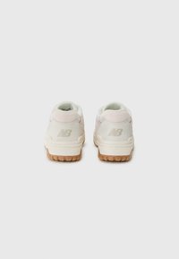 Vita och rosa sneakers med en texturerad tygovandel, gummisula och upphöjd logotyp på hälen. Rundad tå och vadderad krage.