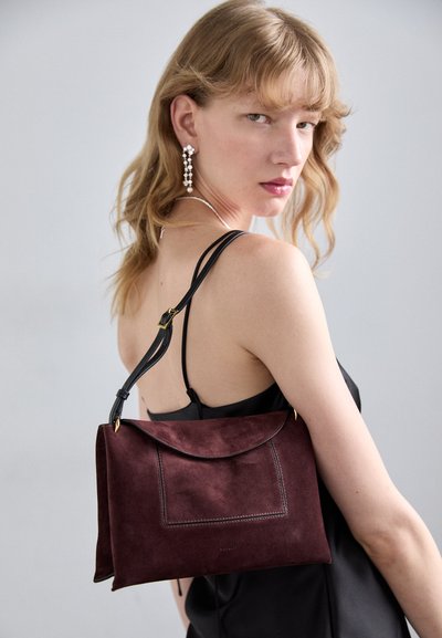 Burgundy mockaskvinsväska med läderrem, med en klaffstängning och en framficka. Slät textur och elegant rektangulär form.