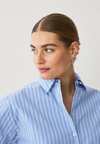 Hellblaues Hemd mit Kragen und feinen vertikalen Streifen, ausgestattet mit einer Knopfleiste und weichem Stoffgefühl. Eignet sich für Freizeit- oder Businesskleidung.