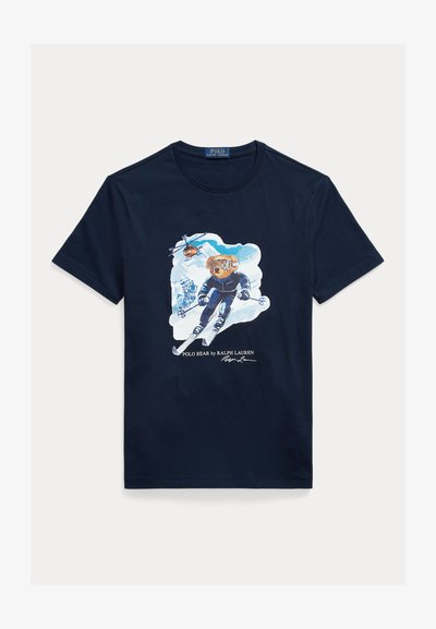 Navy cotton t-shirt featuring a graphic of a bear skiing, wearing goggles, with a helicopter above and snowy mountains in the background.