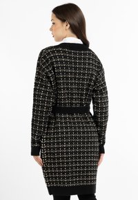 Cardigan nero e crema con motivo, maniche lunghe, polsini a costine e una trama strutturata. Rifinito con una cintura nera.