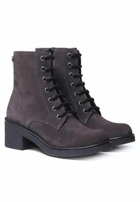 Botas de tobillo de ante gris oscuro con puntera redonda, tacón plano y cordones en la parte frontal. Presentan costuras en contraste y ojetes metálicos plateados.