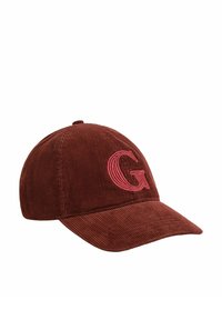 Braune Cord-Baseballkappe mit gebogenem Schirm und einem pinkfarbenen, gestickten Buchstaben "G" auf der Vorderseite. Strukturierter Stoff und verstellbarer Riemen auf der Rückseite.