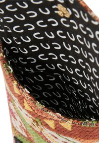 Borsa in tessuto multicolore con motivo floreale, caratterizzata da un esterno testurizzato e una fodera interna nera con disegni bianchi curvi. Bottone con accentuazione dorata.