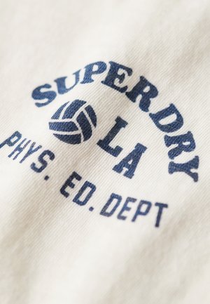 Koszulka w kolorze kremowym z ciemnoniebieskim nadrukiem: "SUPERDRY LA PHYS. ED. DEPT." oraz teksturą grafiki siatkówki.