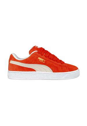 Sneaker in suede rosso con suola e dettagli in gomma bianca. Presenta lacci tondi, branding dorato e un design a strisce testurizzate sui lati.
