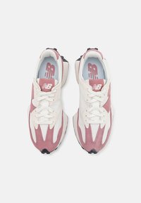 Baskets comprenant une combinaison de cuir blanc et de suède rose. Comprend un design à lacets, un col rembourré et une semelle en caoutchouc noir texturé.