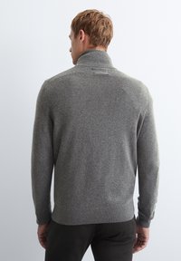 Gray knitted sweater with a high collar, ribbed cuffs, and hem. Soft texture, fitted design, viewed from the back against a plain background.