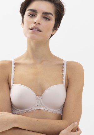 Lyserød polstret BH med blonder langs kanterne, dekorativ sløjfe i midten og justerbare stropper med bølget kant.