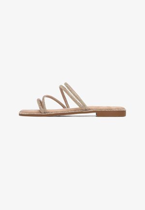 Sandalias planas con tres finas tiras, material beige con un sutil brillo, suela plana y diseño minimalista.