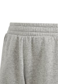 Pantalones de chándal grises con una cinturilla elástica, textura suave y bolsillos laterales, con costuras visibles y un sutil patrón jaspeado.