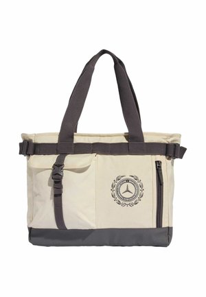 Borsa a tracolla beige e grigio scuro con due manici, cinghia anteriore con fibbia, tasca con cerniera e un emblema circolare con una stella a tre punte e testo.