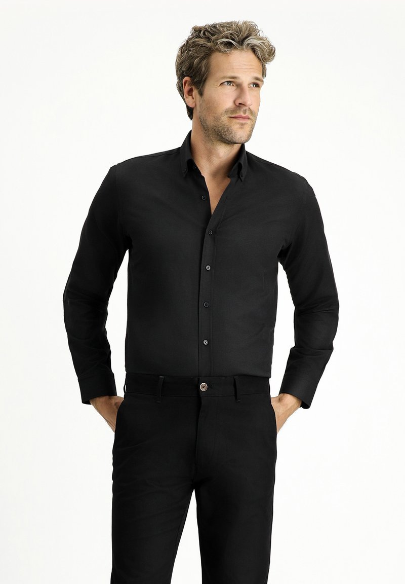 Zwarte langslavige overhemd met knopen en kraag, en bijpassende zwarte broek, met een gladde textuur en klassieke pasvorm.