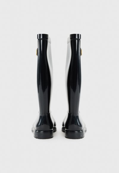 Black rubber rain boots with a glossy finish, tall design, rounded toe, and a small gold accent on the side. Textured sole for grip.