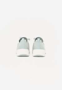 Pair of light grey athletic shoes with white soles, shown from the back on a plain white background.