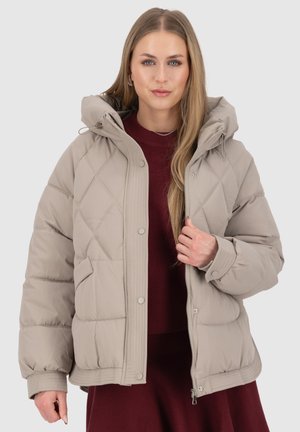 Beige puffer jacket with diamond quilted pattern, adjustable hood, snap buttons, and ribbed cuffs, worn over a dark red sweater.