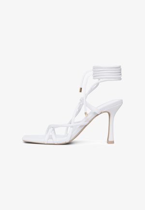 Sandal con tacco bianco caratterizzato da un design con cinghie, tacco a stiletto alto, cinturino imbottito alla caviglia e punta quadrata elegante. Finitura liscia e satinata.