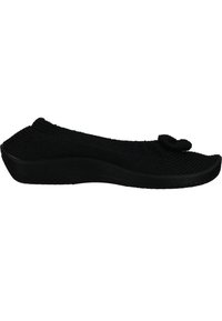 Scarpa nera slip-on realizzata in materiale a maglia testurizzato. Punta arrotondata con un dettaglio decorativo a nodo. Suola in gomma nera spessa, leggermente elevata.