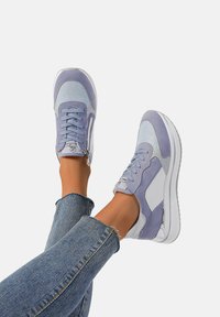 Sneaker viola chiaro con pannelli in suede e mesh, dotati di una suola bianca, chiusura con lacci e un dettaglio con zip di lato.