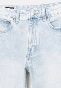 Jean en denim bleu clair avec poches avant, passants de ceinture et fermeture par bouton métallique à la taille.