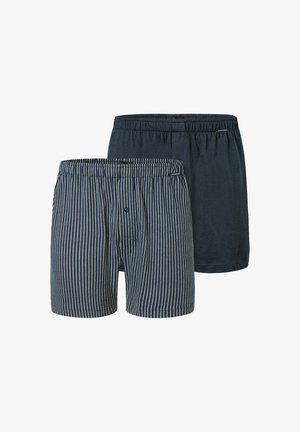 Dois pares de boxers masculinos: um em azul escuro sólido e o outro listrado em azul e branco. Ambos apresentam uma cintura elástica e sem hardware visível.