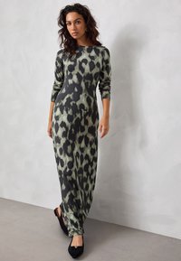 Maxikleid mit langen Ärmeln aus weichem Stoff mit schwarzem und grünem Leopardenmuster; enganliegendes Oberteil und weiter Rock, knöchellang.