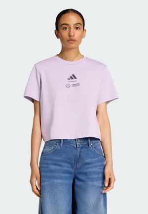 Camiseta corta de color morado claro hecha de algodón, con cuello redondo y mangas cortas, decorada con logotipos negros en el frente.