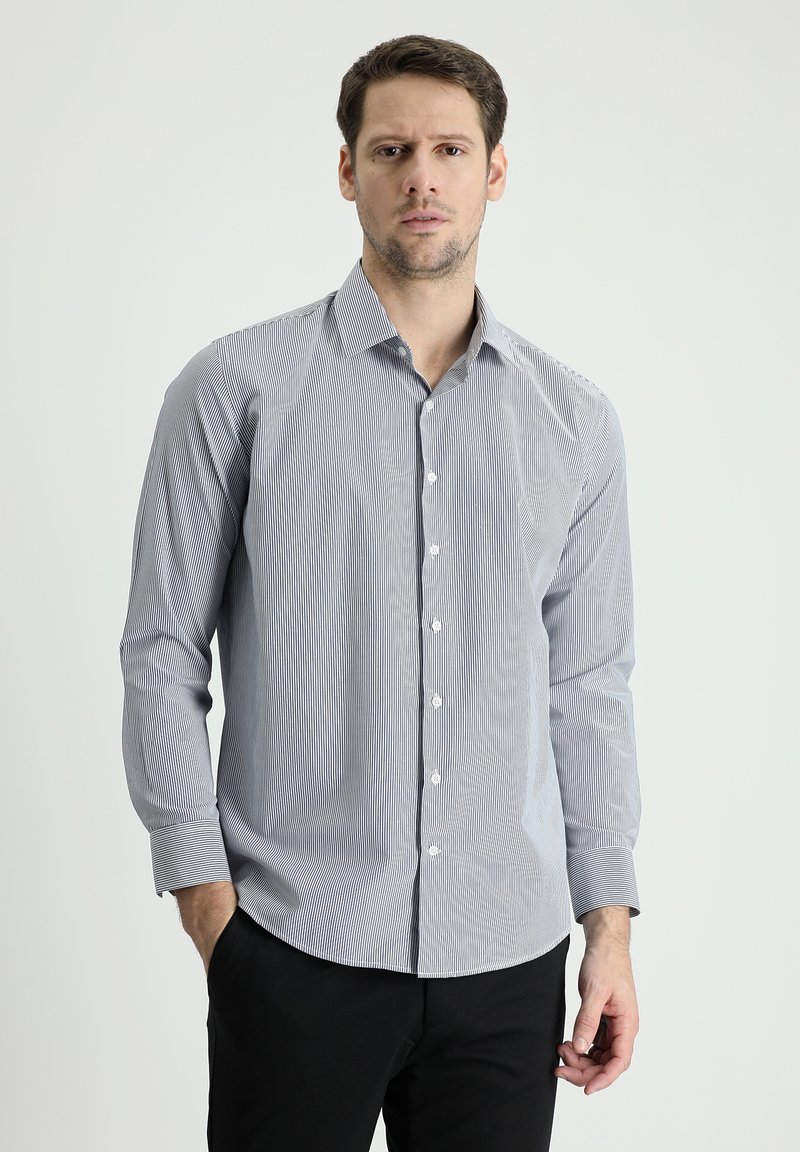 Camisa de manga larga a rayas en algodón blanco y azul claro, con cuello extendido, cierre frontal con botones y puños de un solo botón.