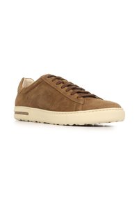 Sneaker in suède marrone con profilo basso, punta rotonda e suola in gomma color crema. Presenta lacci sottili e dettagli di cucitura minimali.
