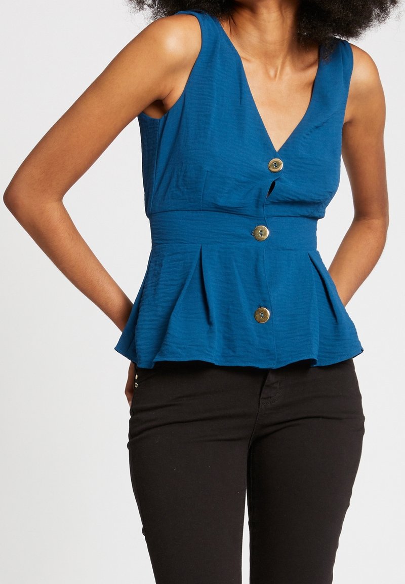 Blue sleeveless top with a V-neck, textured fabric, and three gold buttons at the front, featuring a peplum silhouette and flat seams.