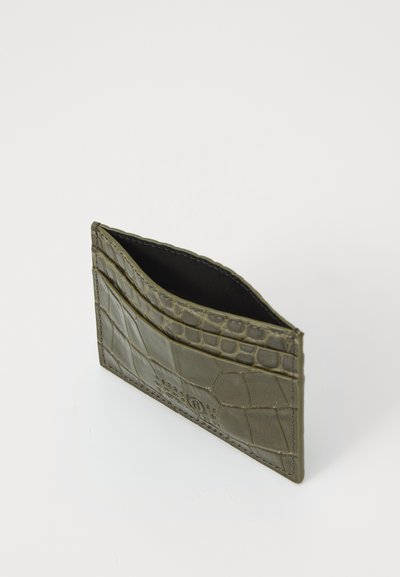 Sottile portafoglio verde oliva con texture coccodrillo e interno in tessuto nero su sfondo bianco.