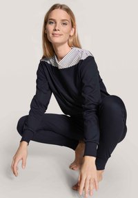 Navy loungewear-set med randig krage, med avslappnad passform och långa ärmar. Materialet verkar slätt med en lätt lyster.