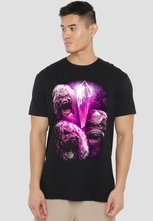 Black t-shirt featuring a graphic of three creature faces and a pink crystal against a purple background. Cotton material with short sleeves.