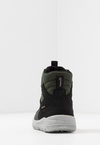 Stivale mid-cut nero e verde con tessuto texturizzato, colletto imbottito, tallone rinforzato e suola in gomma grigia. Presenta un cordino per facilitare l'accesso.