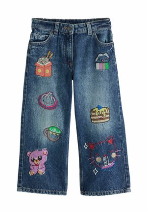 Kinder blaue Denim-Jeans mit bunten bestickten Patches von Lebensmitteln, einem Teddybär und einem Katzengesicht an den Vorderbeinen.
