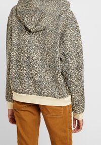 Sudadera con capucha de estampado de leopardo, con una textura suave, puños y dobladillo beige, ajuste holgado y un bolsillo tipo canguro.