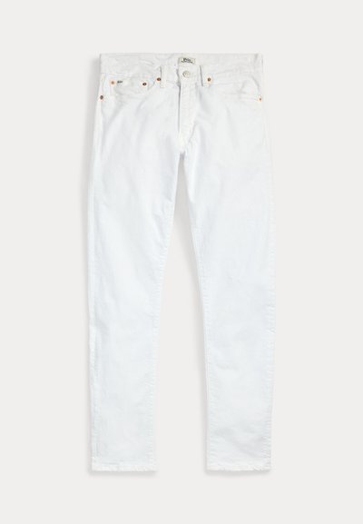 Bílé slim-fit džíny s pěti kapsami, zapínáním na knoflík a poutky na pásek, položené naplocho na jednobarevném světlém pozadí.