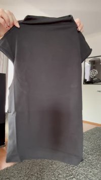 Black short-sleeve dress made of a smooth fabric, featuring a round neckline and a relaxed fit. Flat seams with no visible patterns or accents.
