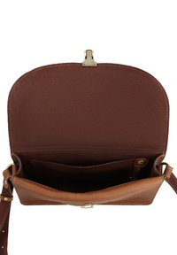 Pruun nahast rihmaga kott, klapp avatud, näidates sisemist taskut ja kuldses toonis kinnitust ning riistvara.