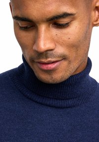 Navyblauer Rollkragenpullover mit geripptem Ausschnitt und Bündchen. Strickstruktur, taillierte Passform und glatte Stoffoberfläche.