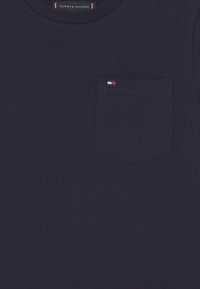 Marineblaues T-Shirt aus Baumwolle mit einer kleinen aufgesetzten Tasche und einem dreifarbigen Logodetail, Rundhalsauschnitt und kurzen Ärmeln.