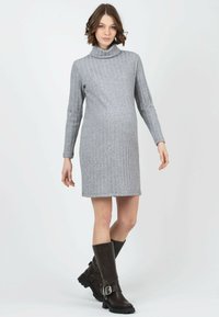 Graues, geripptes Strick-Turtleneck-Kleid mit langen Ärmeln, kombiniert mit dunkelbraunen kniehohen Stiefeln mit einer Schnallenakzenten.