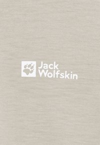 Wit Jack Wolfskin-logo met een pootafdruk symbool op een lichtbeige, gestructureerde stof achtergrond.