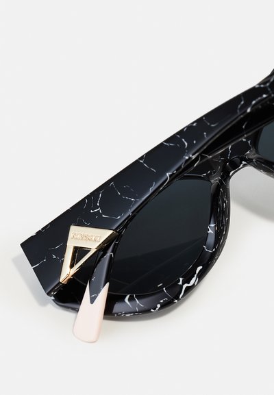 Black sunglasses with a glossy finish, white marble pattern, gold-tone hardware, and a contrasting light-colored accent on the arm.