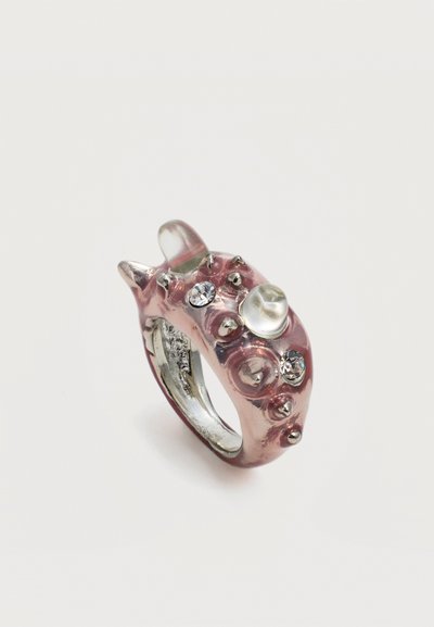 Χοντρό ροζ δαχτυλίδι ρητίνης με ασημένιες αγκάθια, δύο διαφανείς κρύσταλλους και μια χάντρα όμοια με μαργαριτάρι σε λευκό φόντο.