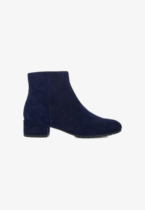 Bottine en daim bleu marine avec un bout arrondi et un talon bloc. Texture lisse avec des coutures minimalistes et sans hardware visible.