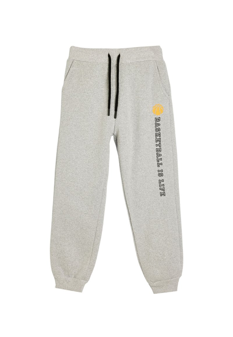 Pantalones de chándal gris claro con cordones negros, bolsillos laterales, puños acanalados y el texto "El baloncesto es la vida" junto a un ícono de baloncesto amarillo en una pierna.