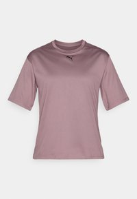 Tricou athletic scurt, de culoare purpuriu deschis, cu mânecă scurtă și guler rotund, având un mic logo negru Puma centrat aproape de guler.
